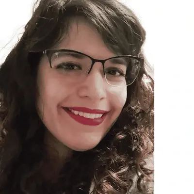 Photo of Michelle Poirier smiling. She has light skin, red lipstick, and dark wavy hair that falls just past her shoulders
